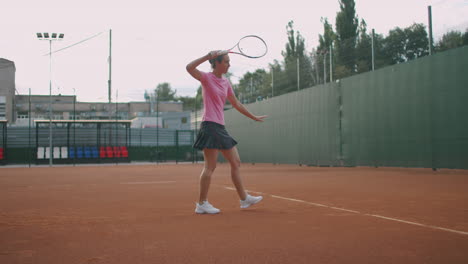 Attractive-Athlete-Poses-Near-Net-In-Tennis-Court.-Young-athletic-female-playing-tennis-walking-in-an-indoor-court-woman-player-become-on-a-game-position-training-day